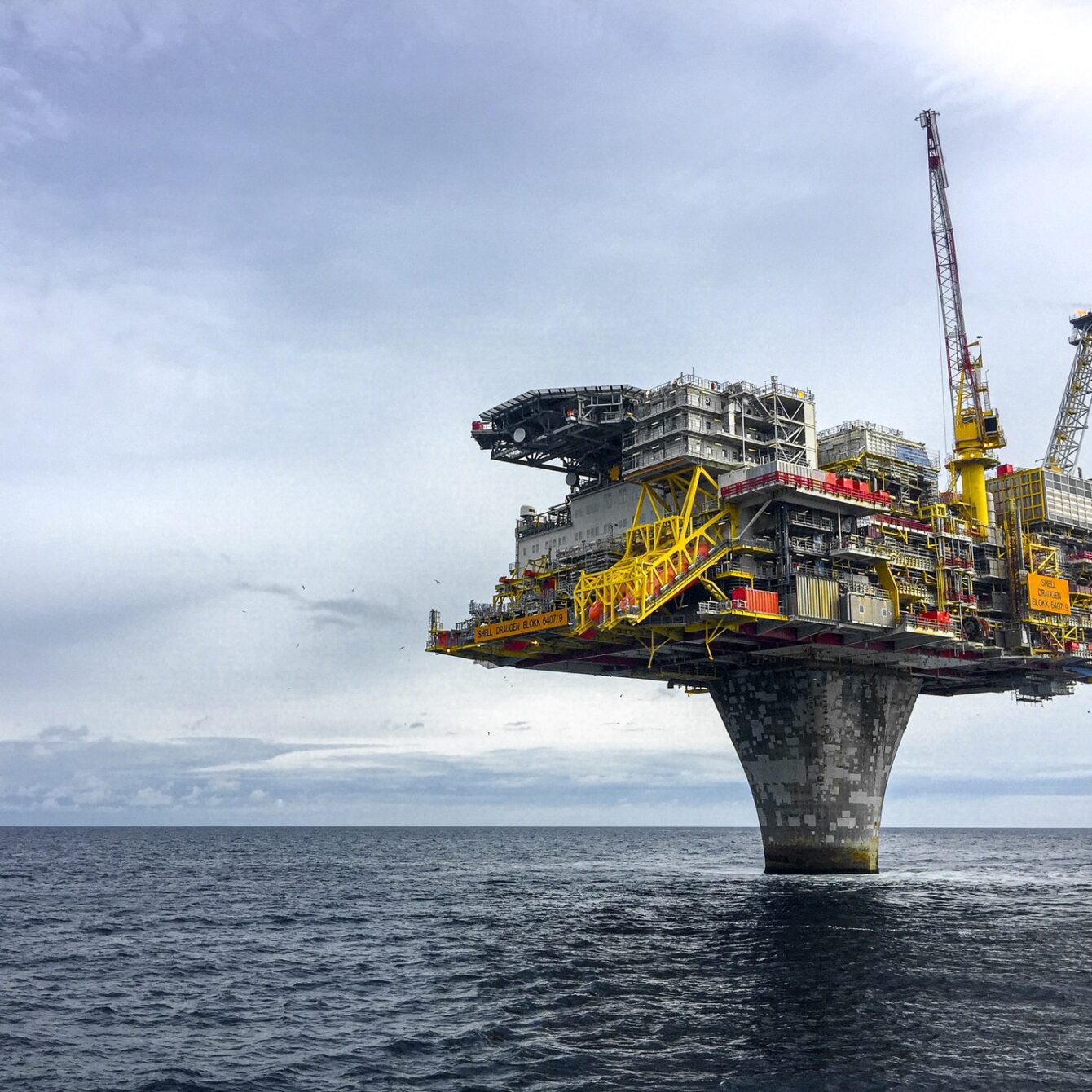Offshore oil platform in the ocean under cloudy sky
